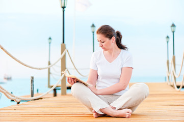 Young girl reading a book while sitting