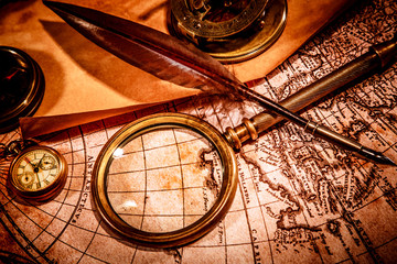 Fototapeta na wymiar Vintage magnifying glass lies on an ancient world map
