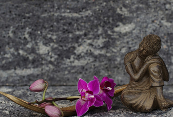 Buddhafigur mit Orchidee