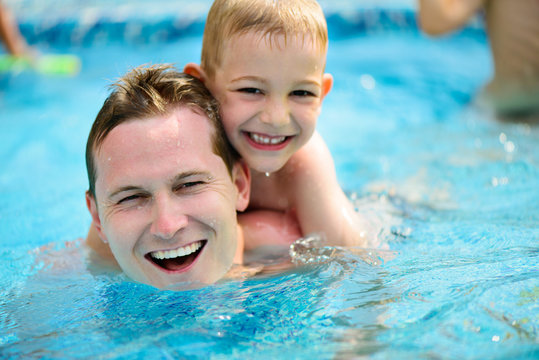 Young father and little son swimming in pool