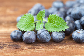 Group of blueberries with leaves on wood