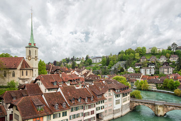 Fototapeta na wymiar Church, bridge and houses with tiled rooftops, Bern