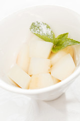 Fresh melon cubes with mint leaves