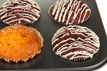 Tasty muffin cakes in baking tray close up