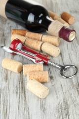 Corkscrew with wine corks and bottle of wine