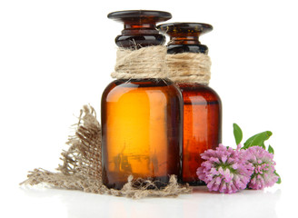 Medicine bottles with clover flowers, isolated on white