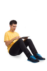 Young man seat using a tablet computer PC, isolated on white 