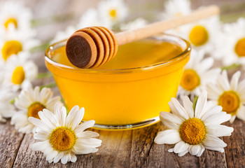 bowl of honey with daisy flowers