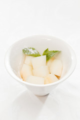 Fresh melon cubes with mint leaves