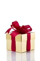 Beautiful gold present box with red bow and ribbons