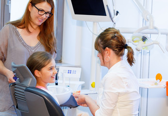 A doctor explains a young family how they can care the teeth