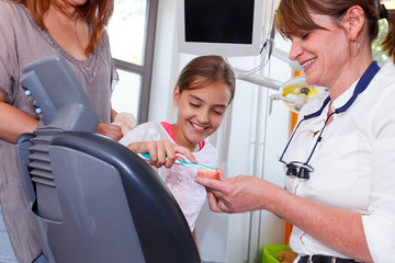 A doctor explains a young family how they can care the teeth