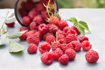 Fresh raspberries in a cup on old wooden table.