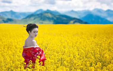 Geisha with bare shoulders in yellow flowering field