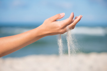 Sand falling from the woman's hand