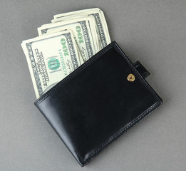Wallet with hundred dollar banknotes, on color background