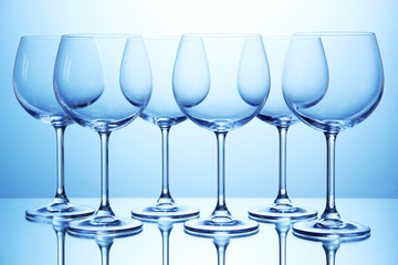 Empty wine glasses arranged on blue background