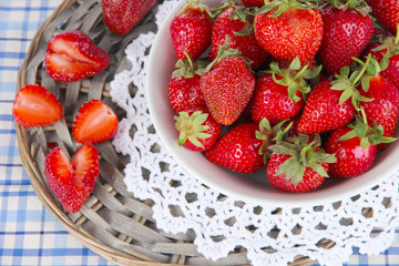 Strawberries in plate on wicker stand on napkin