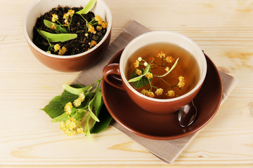 Cup of tea with linden on napkin   wooden table