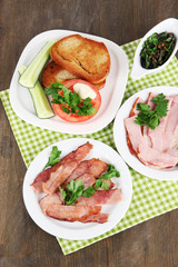 Bacon on plates on napkin on wooden table