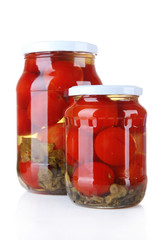 Tasty canned tomatoes in glass jars, isolated on white