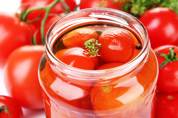 Fototapeta na wymiar Open glass jar of tasty canned tomatoes, close up
