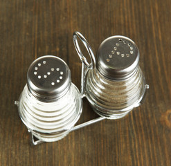 Salt and pepper mills, on wooden background