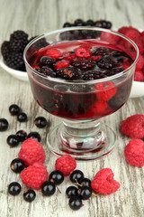 Jelly with fresh berries on wooden table close up