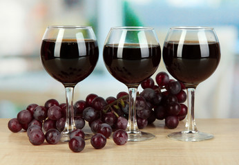 Red wine in glass on room background