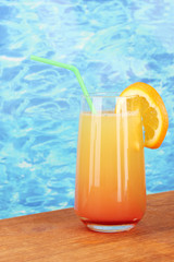 Glass of multicolor cocktail on blue background