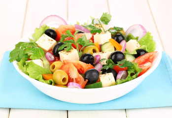 Fresh salad in plate on wooden table
