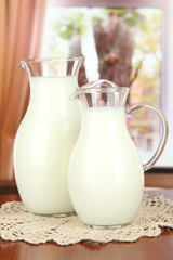 Pitchers of milk on table in room
