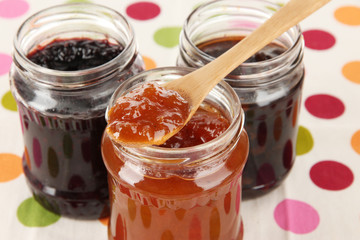 Tasty jam in banks on table close-up