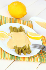 Asparagus on plate, on wooden background