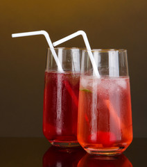 Two cherry cocktails with ice on dark orange background