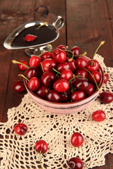 Ripe red cherry berries in bowl and chocolate sauce