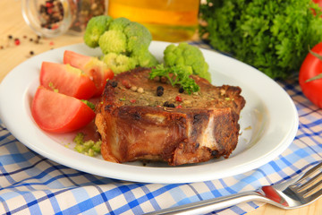 Piece of fried meat on plate on wooden table close-up