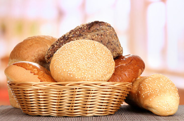 Baked bread in wicker basket on window background