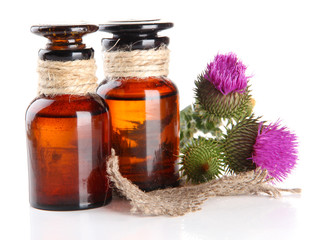 Medicine bottles with thistle flowers, isolated on white