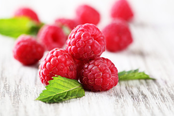 Ripe sweet raspberries on wooden background