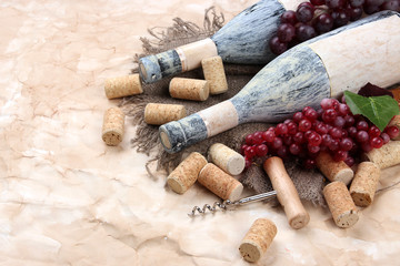 Old bottles of wine, grapes and corks on old paper background