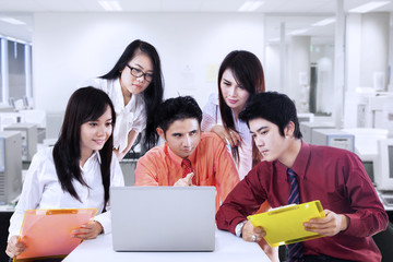 Business manager explains to team in office