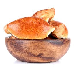 Fresh baked pasties in wooden bowl, isolated on white