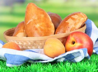 Fresh baked pasties with fruits, in wicker basket,