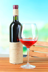 Glasses of wine on wooden table  on nature background