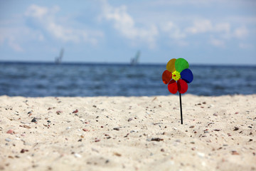Fototapeta na wymiar multicolor pinwheels at the stony beach