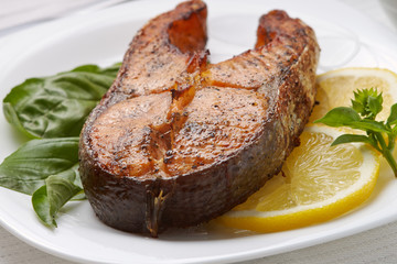 Salmon Steak with Lemon and Basil on white plate