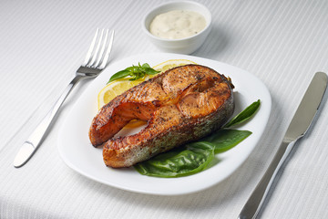 Salmon Steak with Lemon and Basil on white plate