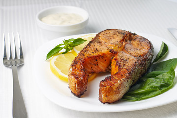 Salmon Steak with Lemon and Basil on white plate