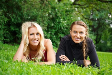 Fototapeta premium Two beautiful smiling girls in a park